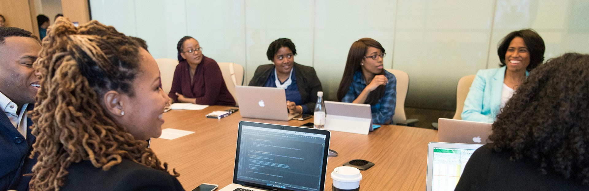 A collaborative group of women entrepreneurs and startup founders gathered around a circular conference table during a professional business discussion. The scene reflects innovation, mentorship, and strategic conversations around startup growth, research commercialization, and federal funding opportunities in a modern entrepreneurial setting.