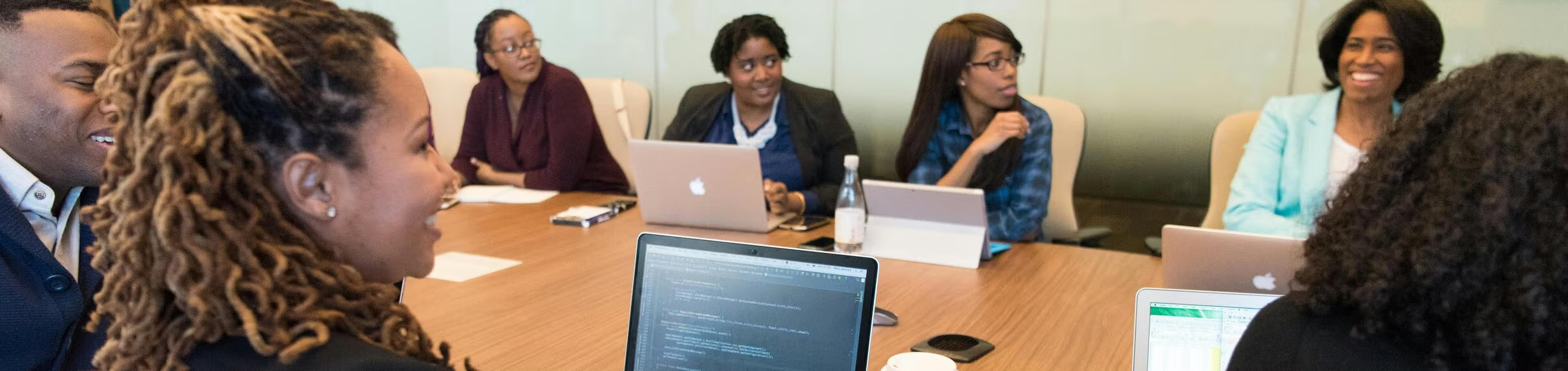 A collaborative group of women entrepreneurs and startup founders gathered around a circular conference table during a professional business discussion. The scene reflects innovation, mentorship, and strategic conversations around startup growth, research commercialization, and federal funding opportunities in a modern entrepreneurial setting.