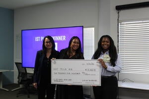 1st Place Winner of 2026 RivCo Fast Pitch Riverside Regional, Keziyah Yisrael-Gayle, representing TollR, pictured with Jennifer Yturralde of UC Riverside and Tiffany Yu of Riverside County, holding a large check of $2,500.