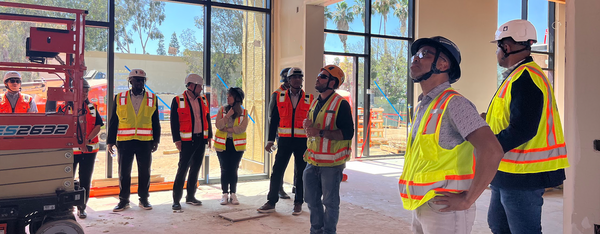 Cisco team and UCE team wearing construction vests and hard hats at the construction site of SoCal OASIS Park.