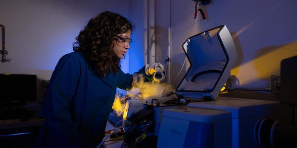 A technician wearing a UCR lab coat working on technology in the CE-CERT Lab