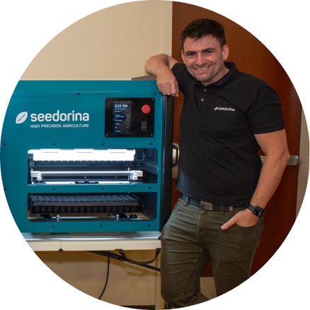 Co-founder of Seedorina Pablo Rodrigo standing beside Seedorina's invention, the Seedbot