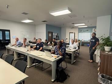 Entrepreneurs participating in UC Riverside's SBIR Phase I Workshop seated at classroom tables with laptops during an in-person training session focused on customer discovery and commercialization.